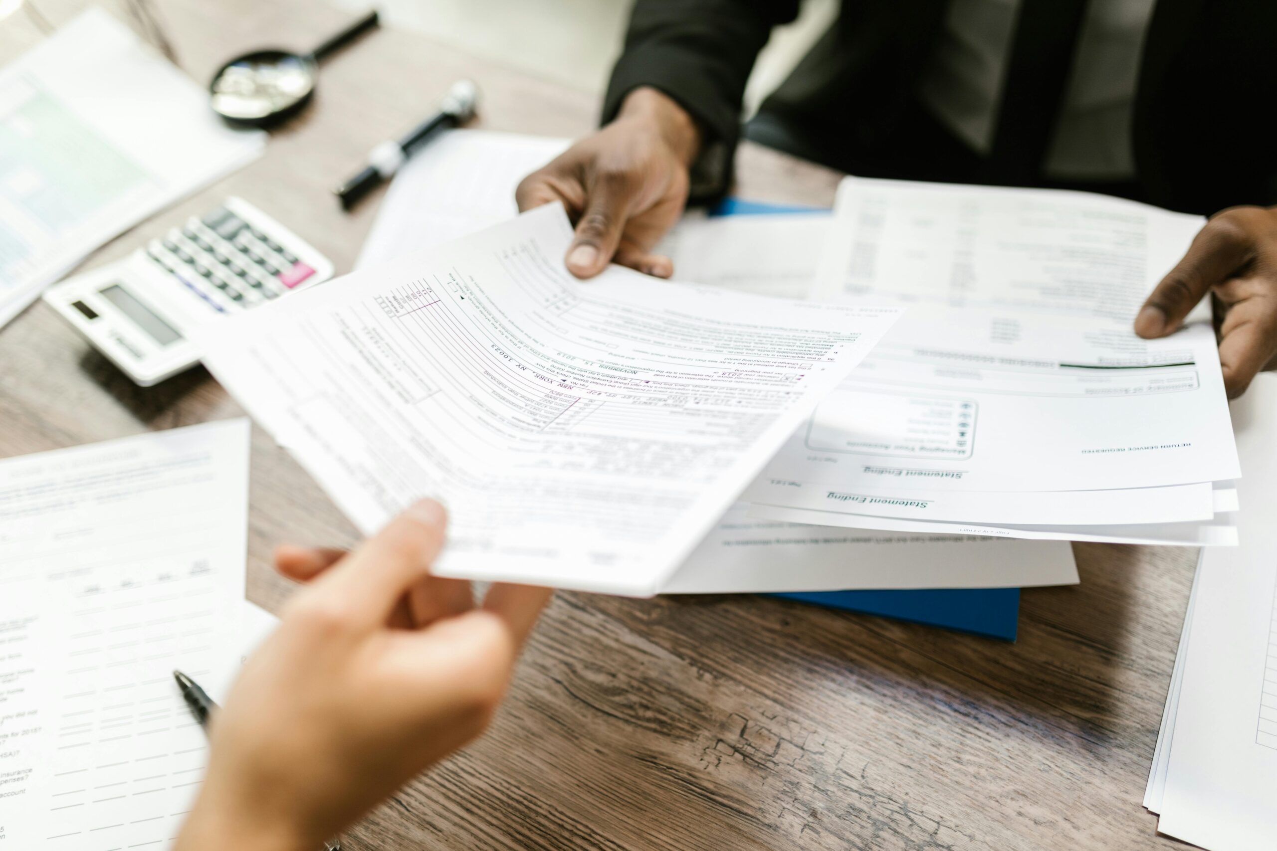 Insurance claim form being filled out at a desk with pen and calculator nearby