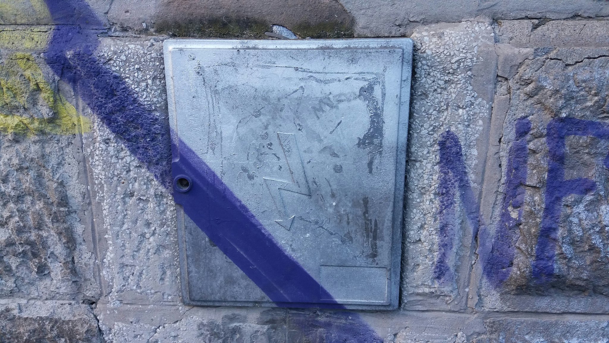 A before-and-after photo showing cleaned-up graffiti on a brick wall, emphasizing successful claim processing.