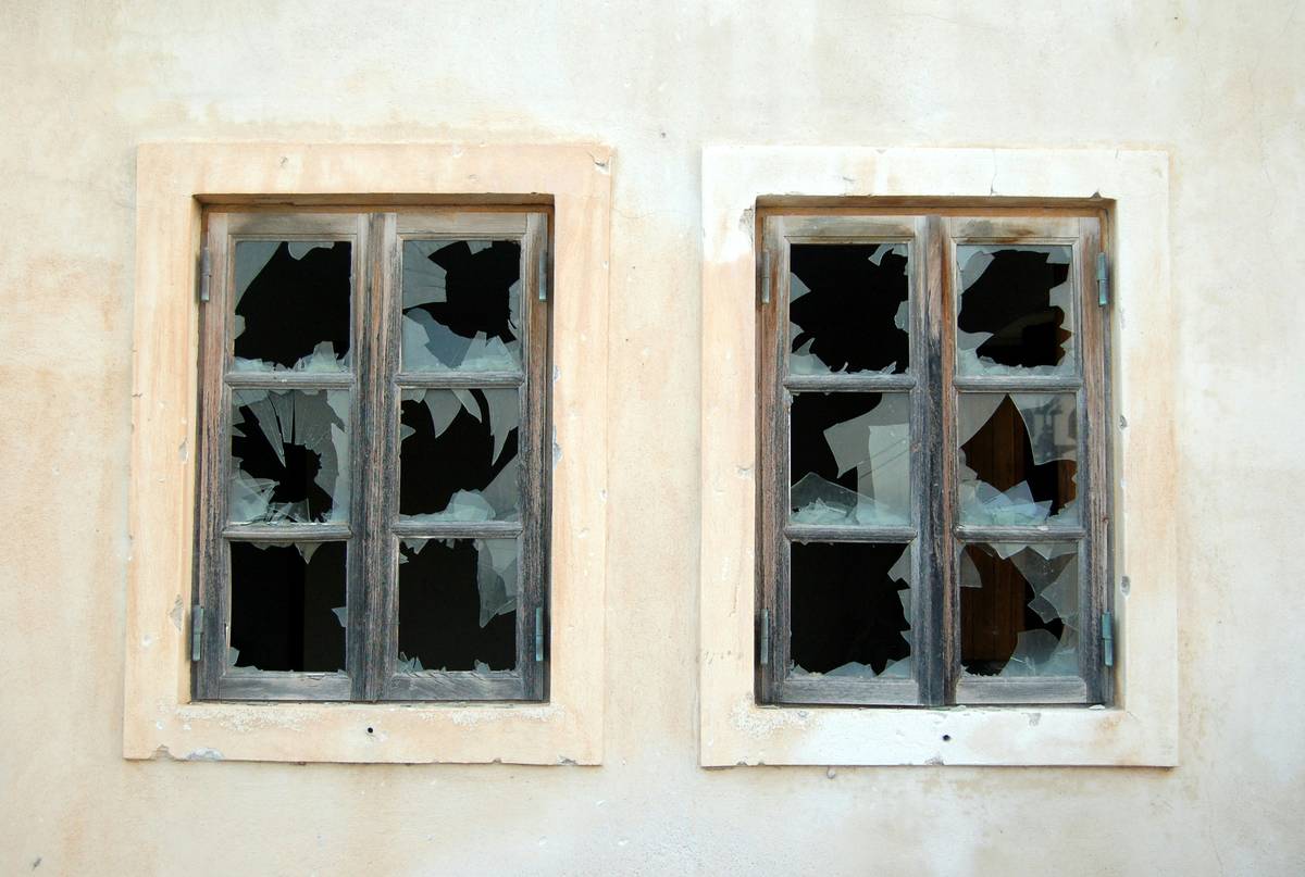 Photo of a vandalized rental property showcasing broken windows and graffiti