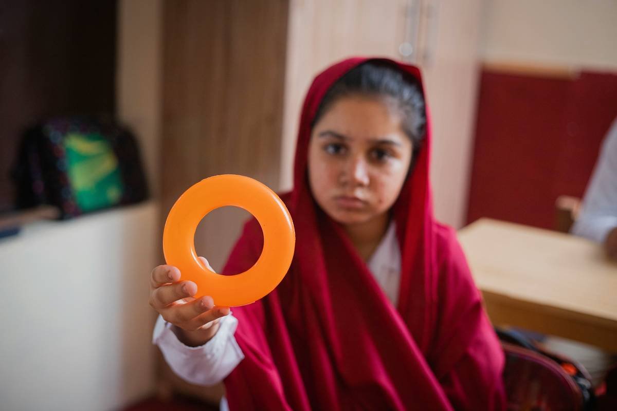 A Small student girl showing how to learn colors in Classroom