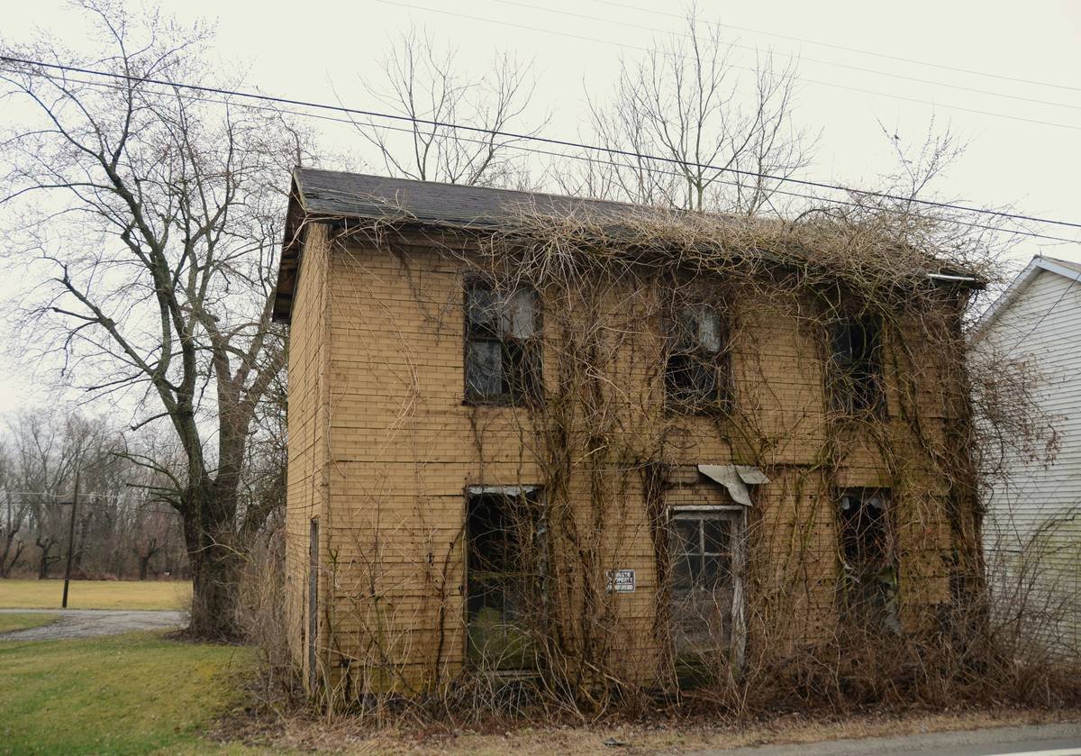 Spooky o;d abandoned building being choked by weeds